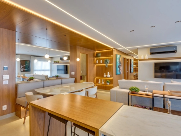 Área de jantar do apartamento Tempus com painéis de madeira, espelhos amplos e pendentes modernos sobre a mesa.