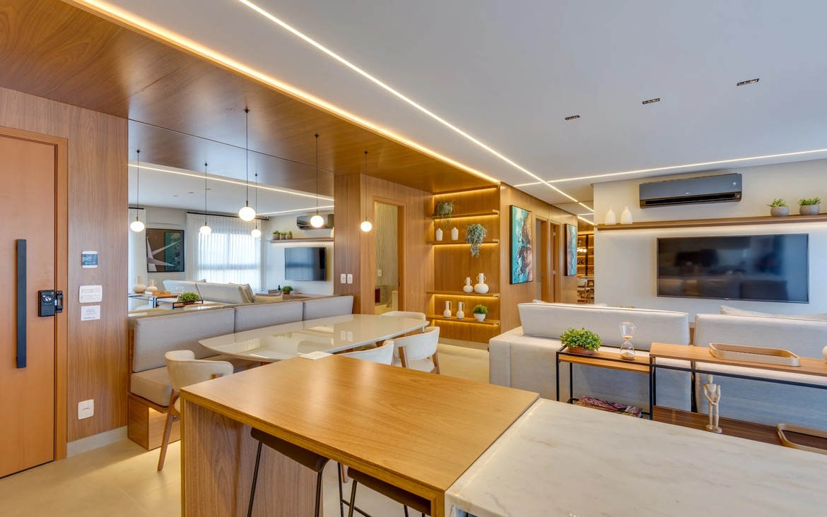 Área de jantar do apartamento Tempus com painéis de madeira, espelhos amplos e pendentes modernos sobre a mesa.