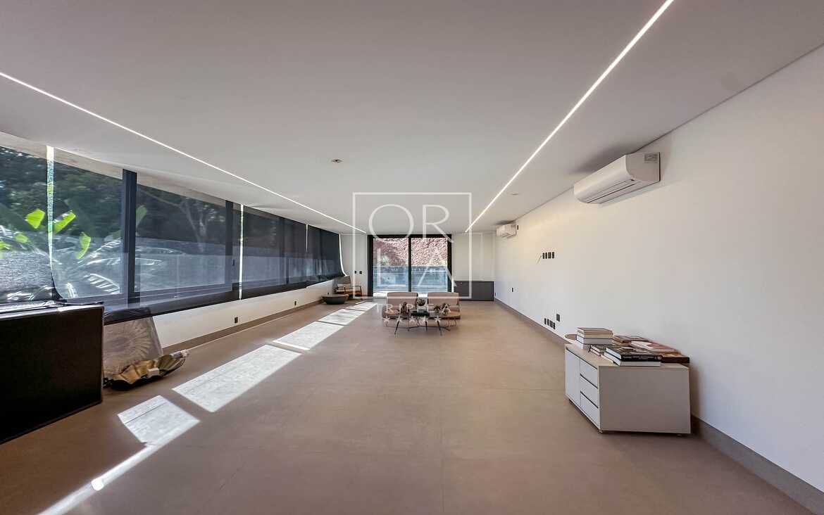 Corredor ou sala técnica extensa com iluminação de trilho e pé direito alto.