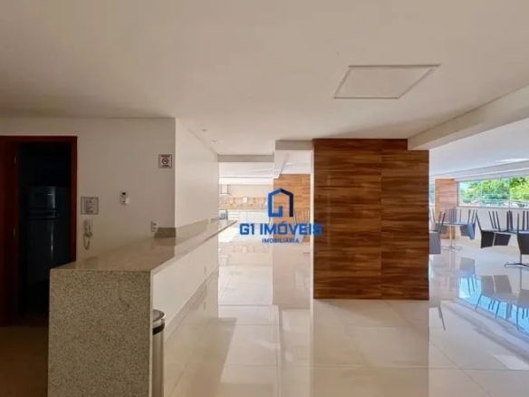 Salão de festas amplo e sofisticado com piso de porcelanato brilhante e áreas de convivência no Residencial Auge.