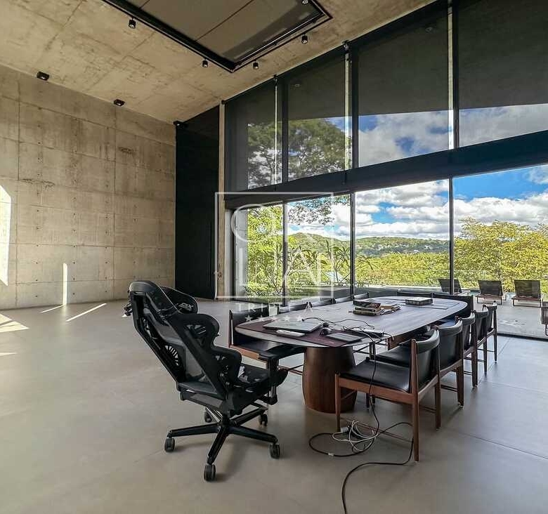 Escritório com grandes janelas de vidro e vista externa no Aldeia do Vale.