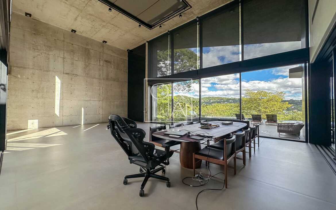 Escritório com grandes janelas de vidro e vista externa no Aldeia do Vale.