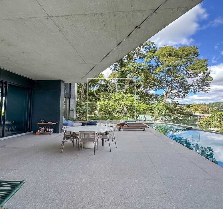 Varanda coberta com mesa de jantar externa e vista para a piscina.