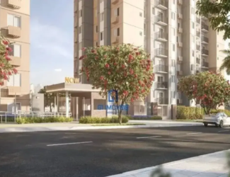 Fachada do residencial Now Milão com portaria moderna, torres altas e rua arborizada em dia de sol.