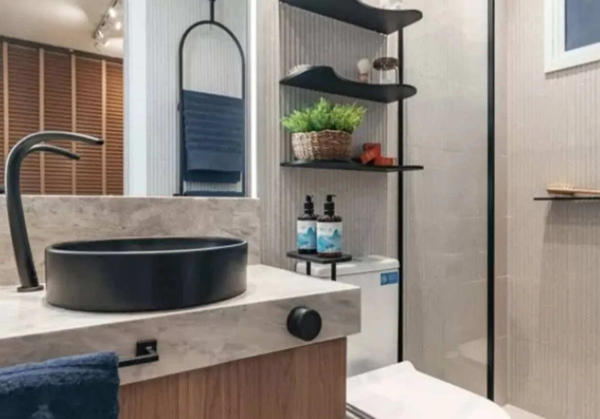 Banheiro moderno com bancada de mármore e cuba preta de sobreporno condomínio Now Praça C8, Setor sudoeste, Goiânia.