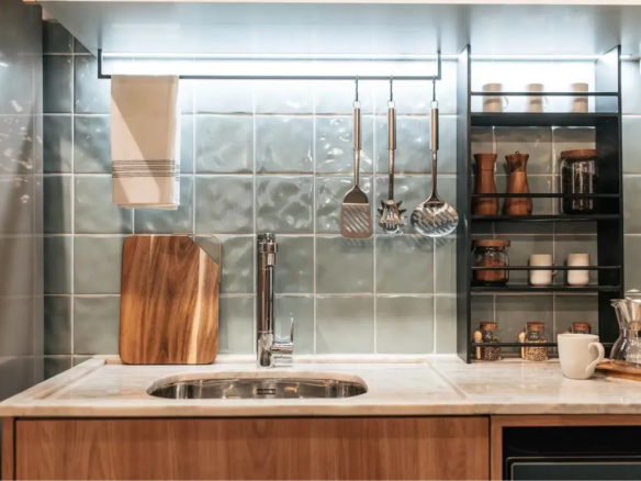 Detalhe da cozinha gourmet do Now Praça C8, com revestimento artesanal, bancada de pedra e marcenaria no Setor Sudoeste.