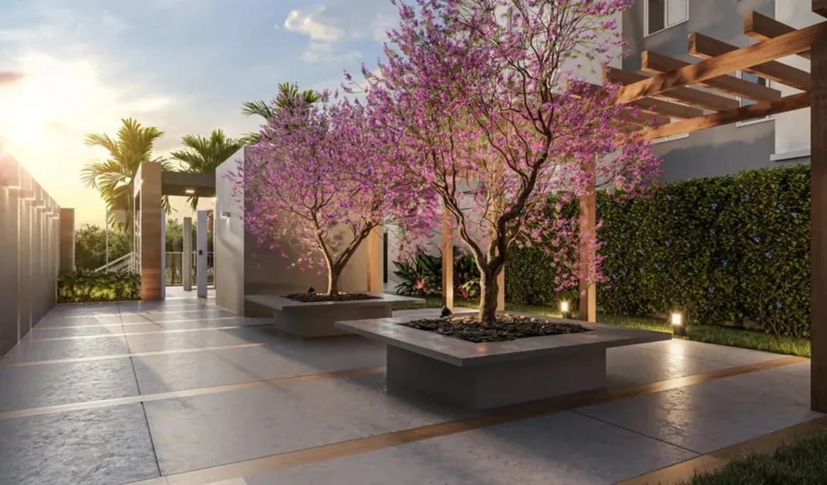 Área externa do Now praça C8 com paisagismo, árvores floridas e iluminação planejada ao entardecer, no Setor Sudoeste.
