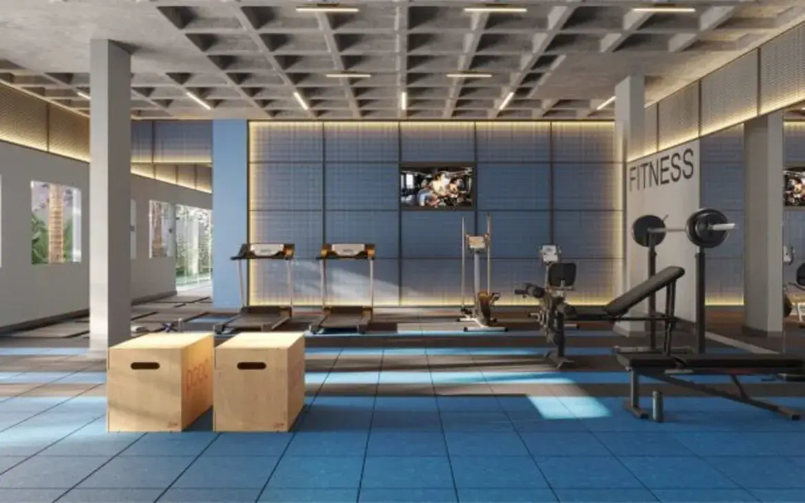 Academia do prédio equipada com esteiras, bicicletas ergométricas e aparelhos de musculação em piso emborrachado.