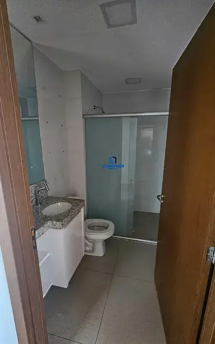 Banheiro social com acabamento em mármore e box instalado.