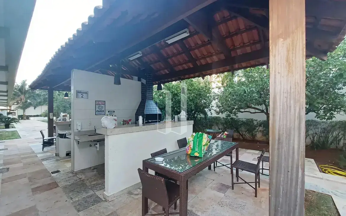 Quiosque gourmet com churrasqueira e mesas na área externa do Condomínio Residencial You.