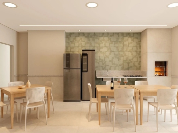 Salão de festas e espaço gourmet equipado com churrasqueira, geladeira e mesas de madeira clara.