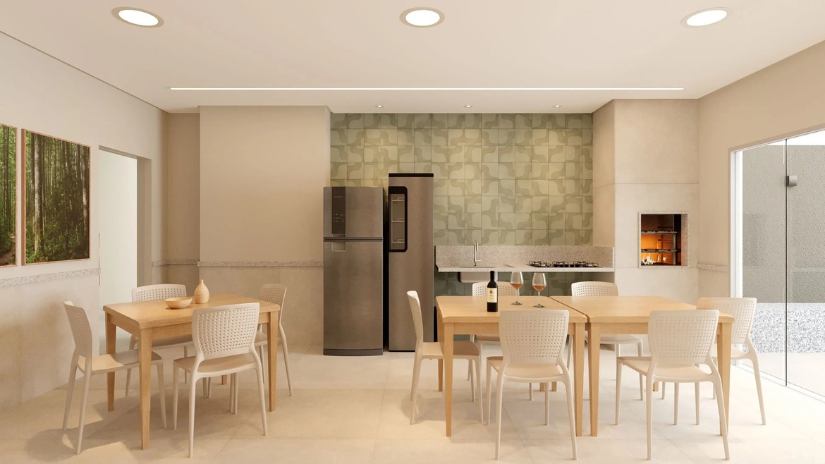 Salão de festas e espaço gourmet equipado com churrasqueira, geladeira e mesas de madeira clara.