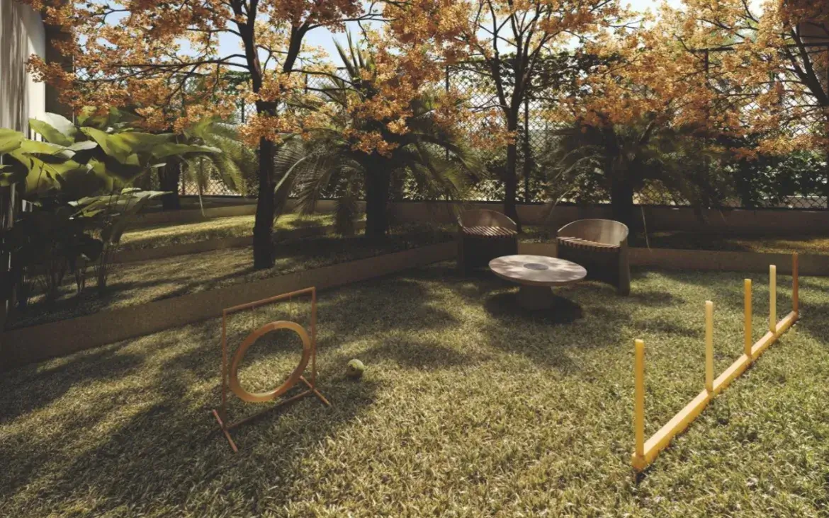 Área de lazer Pet Care com gramado e equipamentos de agility no jardim do condomínio Fascino Consciente.