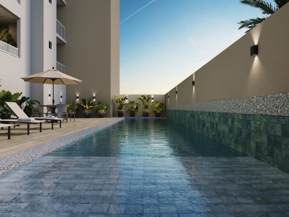 Piscina com raia de natação, revestimento em pedras verdes e deck molhado para espreguiçadeiras.