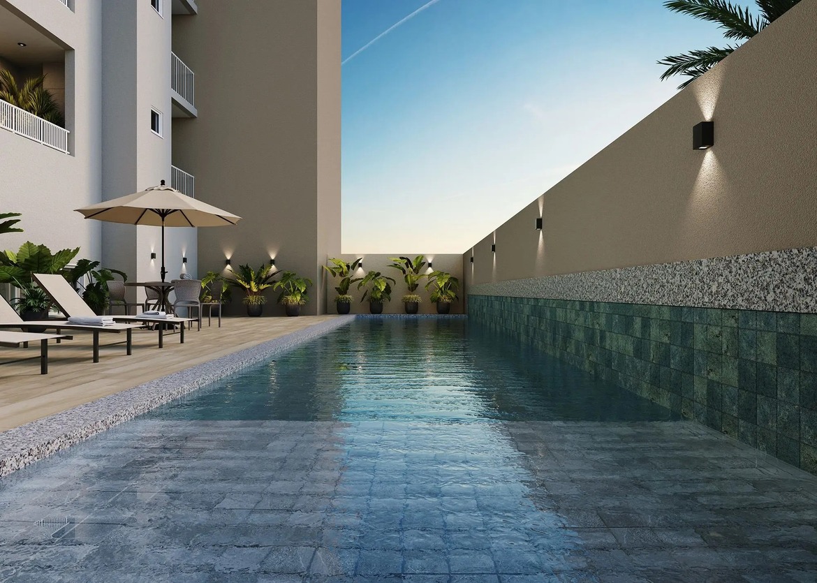 Piscina com raia de natação, revestimento em pedras verdes e deck molhado para espreguiçadeiras.