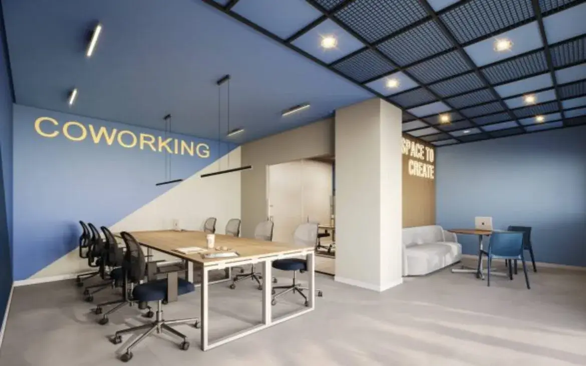 Sala de coworking moderna com mesas compartilhadas, design criativo e iluminação adequada para trabalho remoto.
