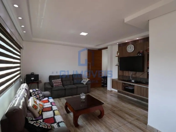 Sala de estar moderna com painel de madeira para TV, iluminação embutida no teto e piso claro.