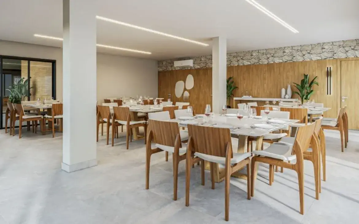 Salão de festas interno com decoração sofisticada, mesas de madeira e cadeiras de design moderno.