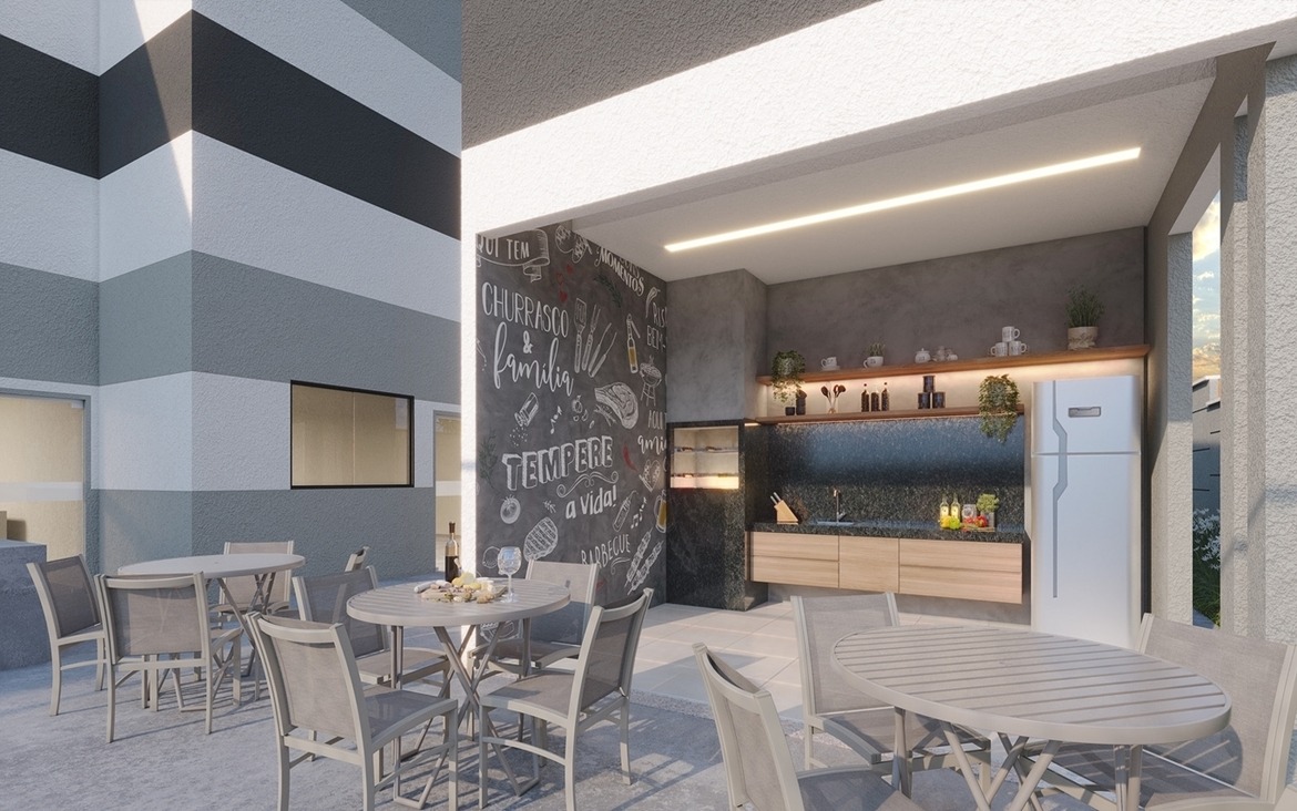 Área gourmet externa coberta com churrasqueira, pia e mesas de apoio.