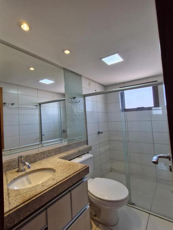 banheiro-moderno-bancada-granito-espelho Banheiro moderno com bancada de granito, espelho amplo e box de vidro transparente.