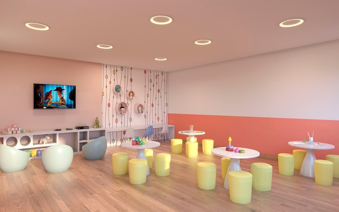 Brinquedoteca colorida e equipada com mesas e TV para diversão das crianças.