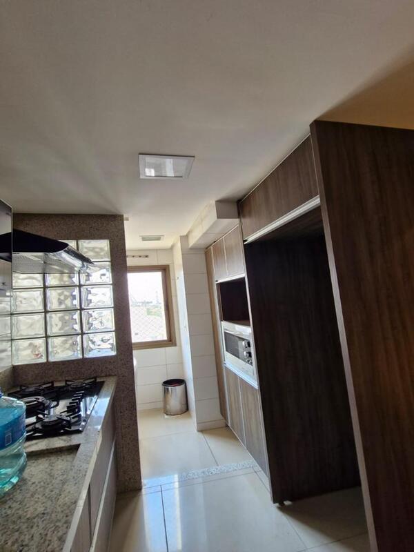 cozinha-equipada-cooktop-residencial-flora-viva Cozinha equipada com cooktop, coifa e divisória de tijolos de vidro no Residencial Flora Viva.