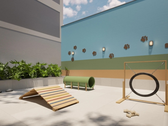 Espaço pet outdoor com obstáculos de agilidade e decoração temática de patinhas na parede.