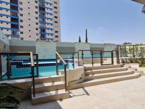 Área da piscina externa com deck, escadas de acesso e grade de proteção no Residencial Flora Viva.