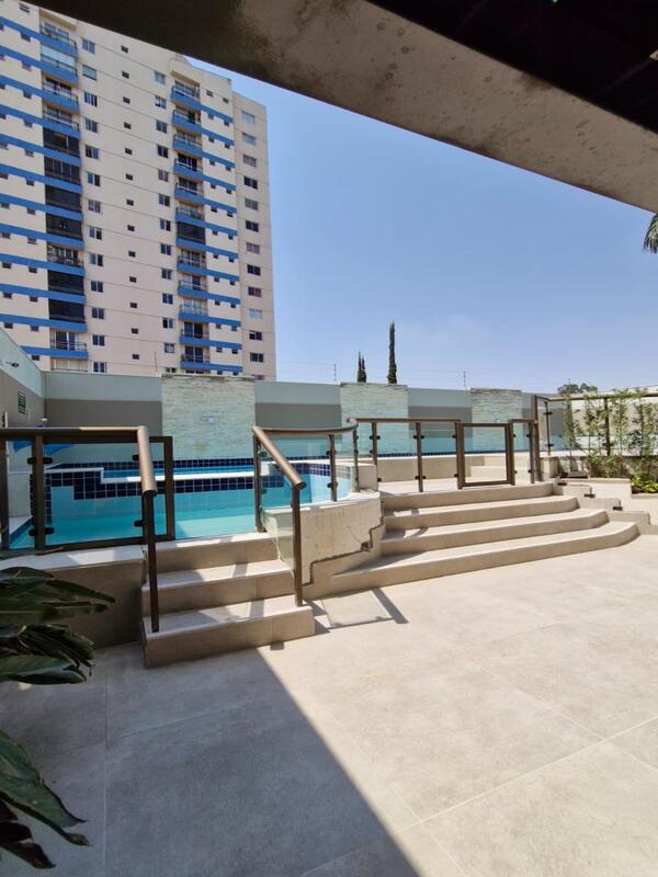 piscina-externa-lazer-residencial-flora-viva Área da piscina externa com deck, escadas de acesso e grade de proteção no Residencial Flora Viva.