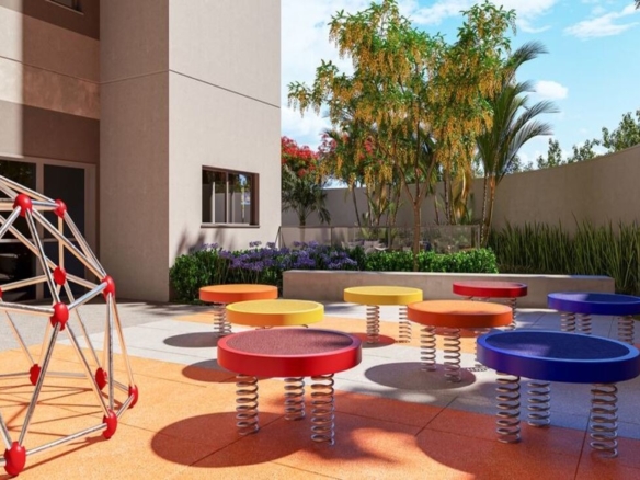 Playground infantil ao ar livre com piso emborrachado colorido, pula-pulas e domo de escalada.