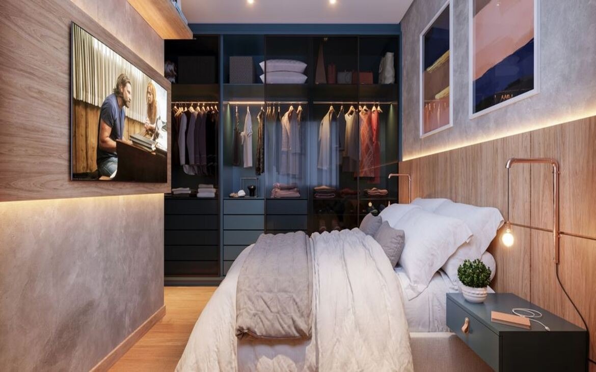 Quarto de casal aconchegante com armário de portas de vidro, cabeceira em madeira e TV na parede.