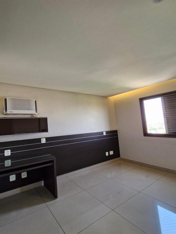 quarto-escritorio-home-office Quarto com bancada de trabalho em madeira escura, painel e ar-condicionado instalado.