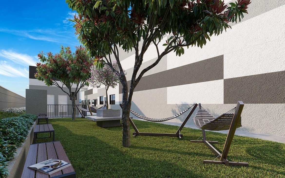 Redário ao ar livre em área gramada e arborizada para descanso.