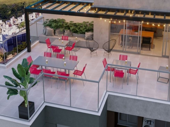 Rooftop do Dot Bild ao entardecer, com cadeiras vermelhas, varal de luzes e integração com espaço gourmet.