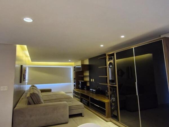 Interior da sala de estar ampla com iluminação quente e sancas de gesso no Residencial Flora Viva.