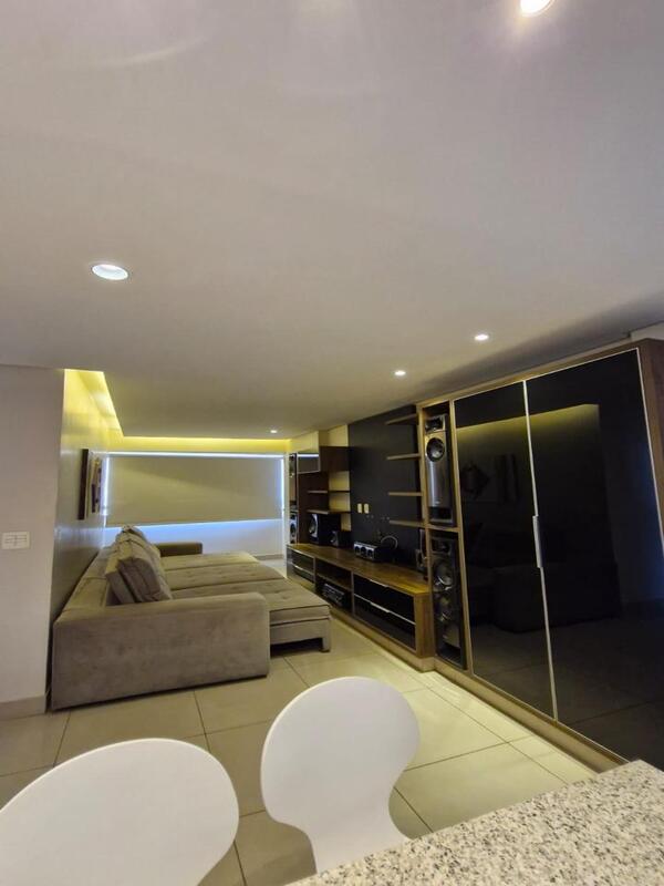 sala-estar-ampla-residencial-flora-viva Interior da sala de estar ampla com iluminação quente e sancas de gesso no Residencial Flora Viva.