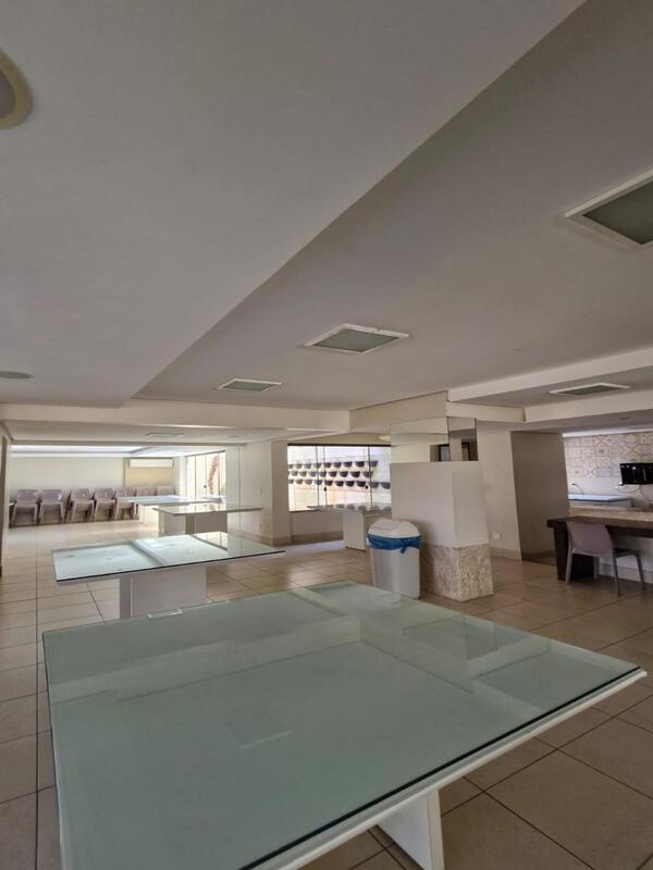 salao-festas-mesas-vidro-comunitario Grande salão comum com mesas de vidro e ambiente climatizado para eventos.