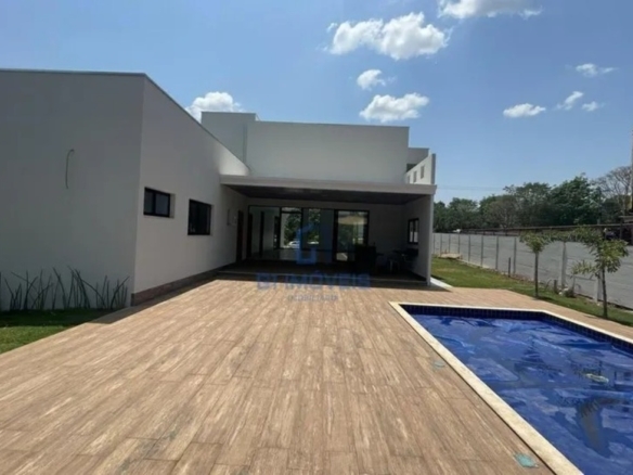 Vista panorâmica do quintal no Aldeia do Vale com piscina, varanda gourmet e amplo espaço gramado.