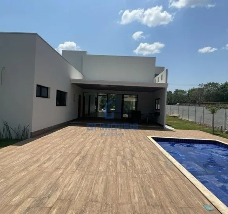 Vista panorâmica do quintal no Aldeia do Vale com piscina, varanda gourmet e amplo espaço gramado.