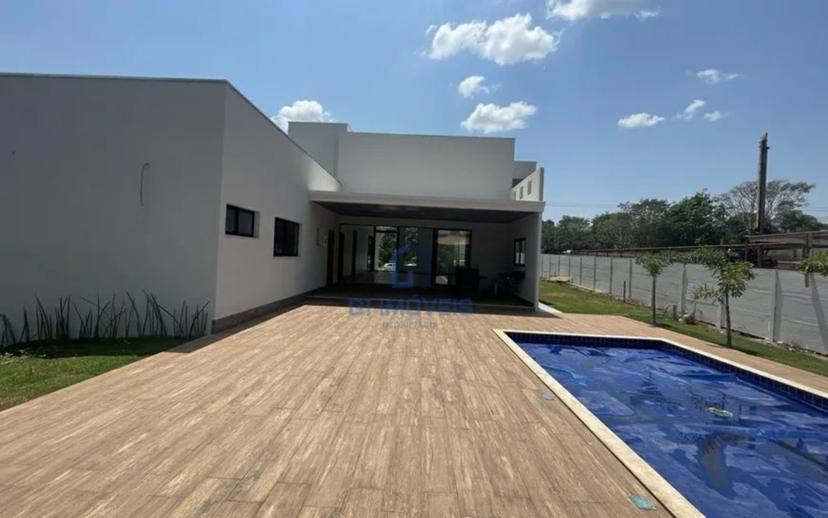 Vista panorâmica do quintal no Aldeia do Vale com piscina, varanda gourmet e amplo espaço gramado.