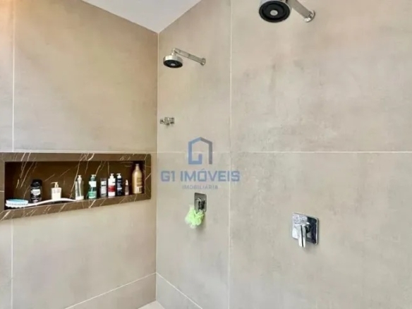 Box de banheiro moderno com dois chuveiros de teto e nicho embutido.