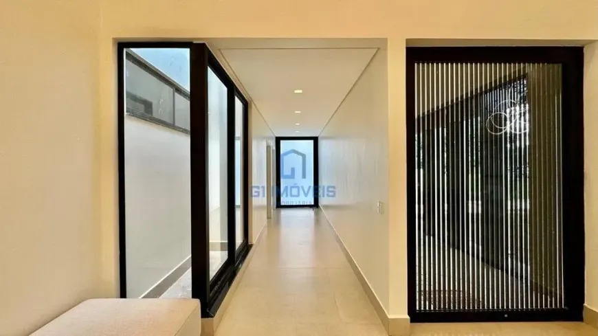 corredor-moderno-aldeia-do-vale Corredor interno minimalista com painel ripado e portas de vidro no Aldeia do Vale.