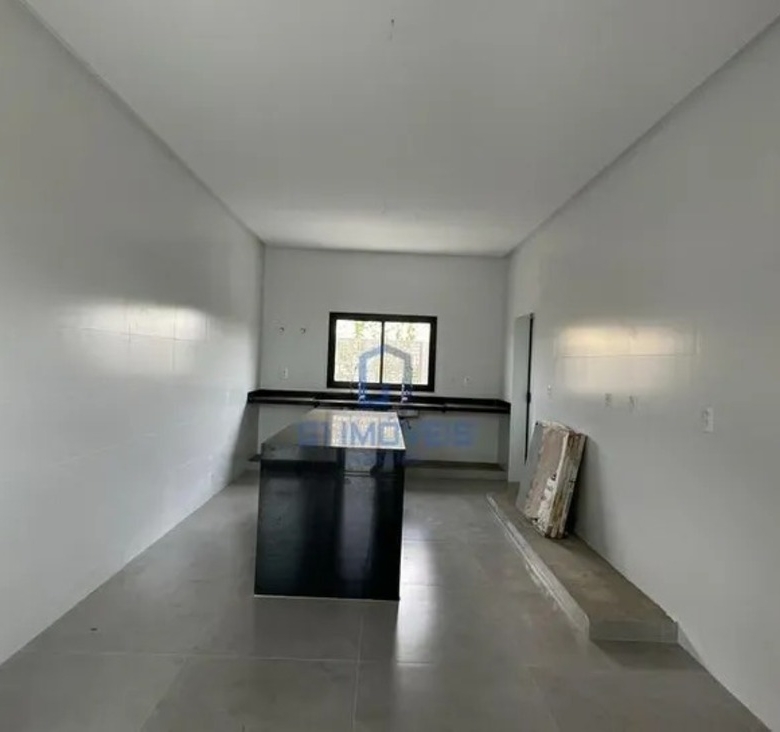 Cozinha planejada com design clean, bancada funcional e piso em porcelanato polido de grande formato.