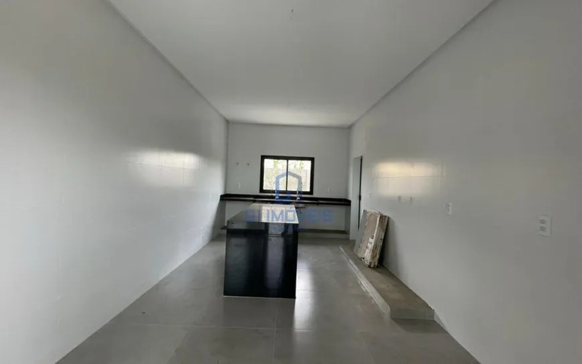 Cozinha planejada com design clean, bancada funcional e piso em porcelanato polido de grande formato.