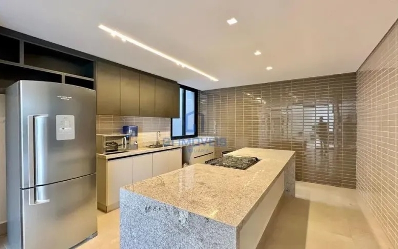 Detalhe de cozinha moderna com bancada de granito e eletrodomésticos em inox.