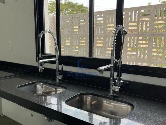 Detalhe de acabamento premium com torneira monocomando gourmet e cuba dupla em aço inox.