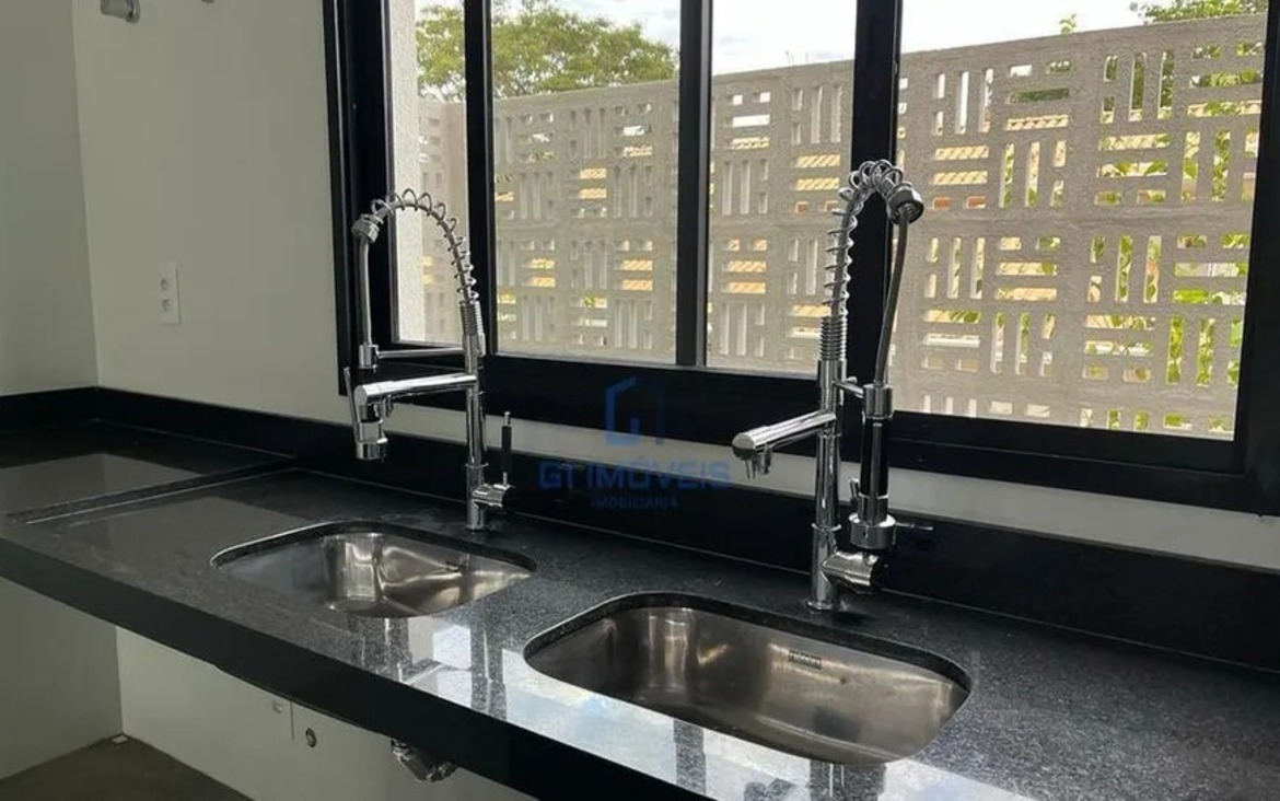 Detalhe de acabamento premium com torneira monocomando gourmet e cuba dupla em aço inox.
