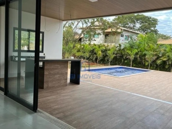 Vista interna da sala integrada com o deck da piscina no Residencial Aldeia do Vale através de esquadrias de alto padrão.