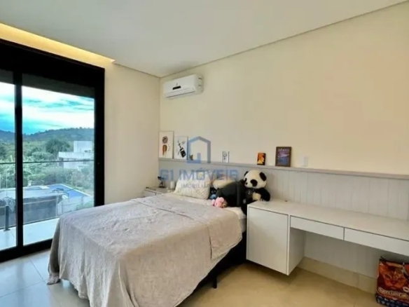 Quarto de hóspedes com marcenaria branca e vista privilegiada para o horizonte.