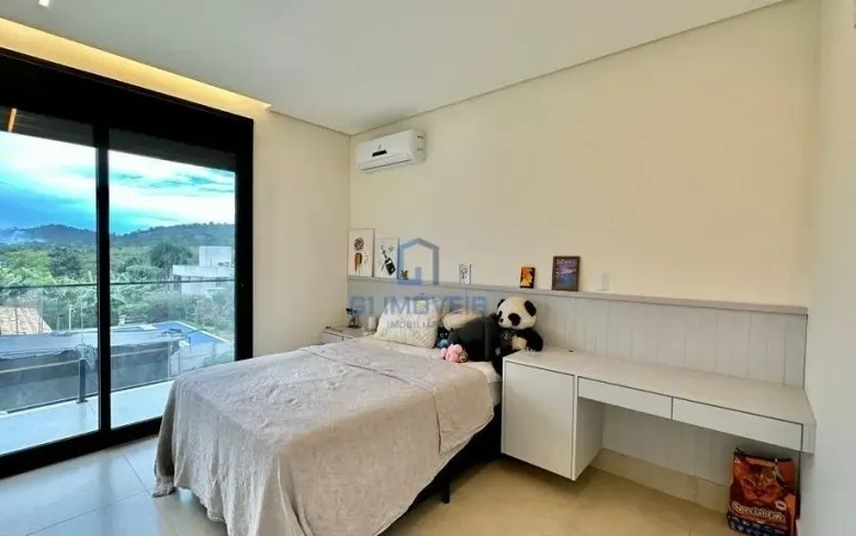 Quarto de hóspedes com marcenaria branca e vista privilegiada para o horizonte.